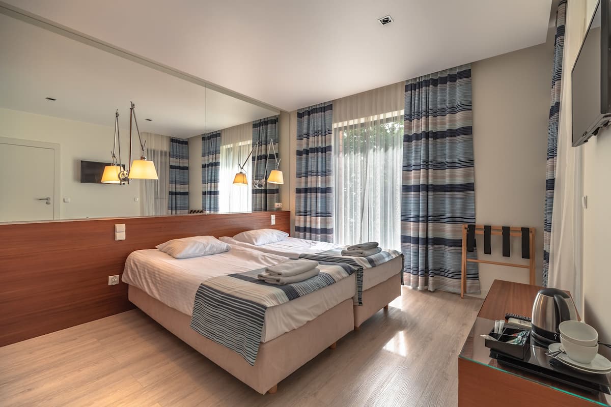 Habitación Confort doble, 2 camas individuales, vistas parciales al lago | 1 dormitorio, tabla de planchar con plancha, ropa de cama