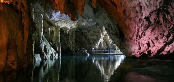 A cave with stalactites and stalagmites, a calm pool, and a bridge. - B&B Kalimaka (San Giovanni a Piro)