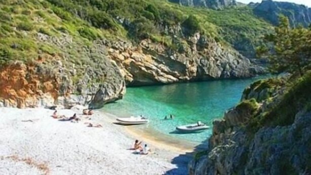A beach with rocky cliffs, clear turquoise water, and a few boats. - B&B Kalimaka (San Giovanni a Piro)