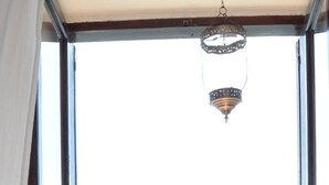 A balcony with a view of the sea and boats, a hanging lantern, and a railing with decorative elements. - B&B Kalimaka (San Giovanni a Piro)