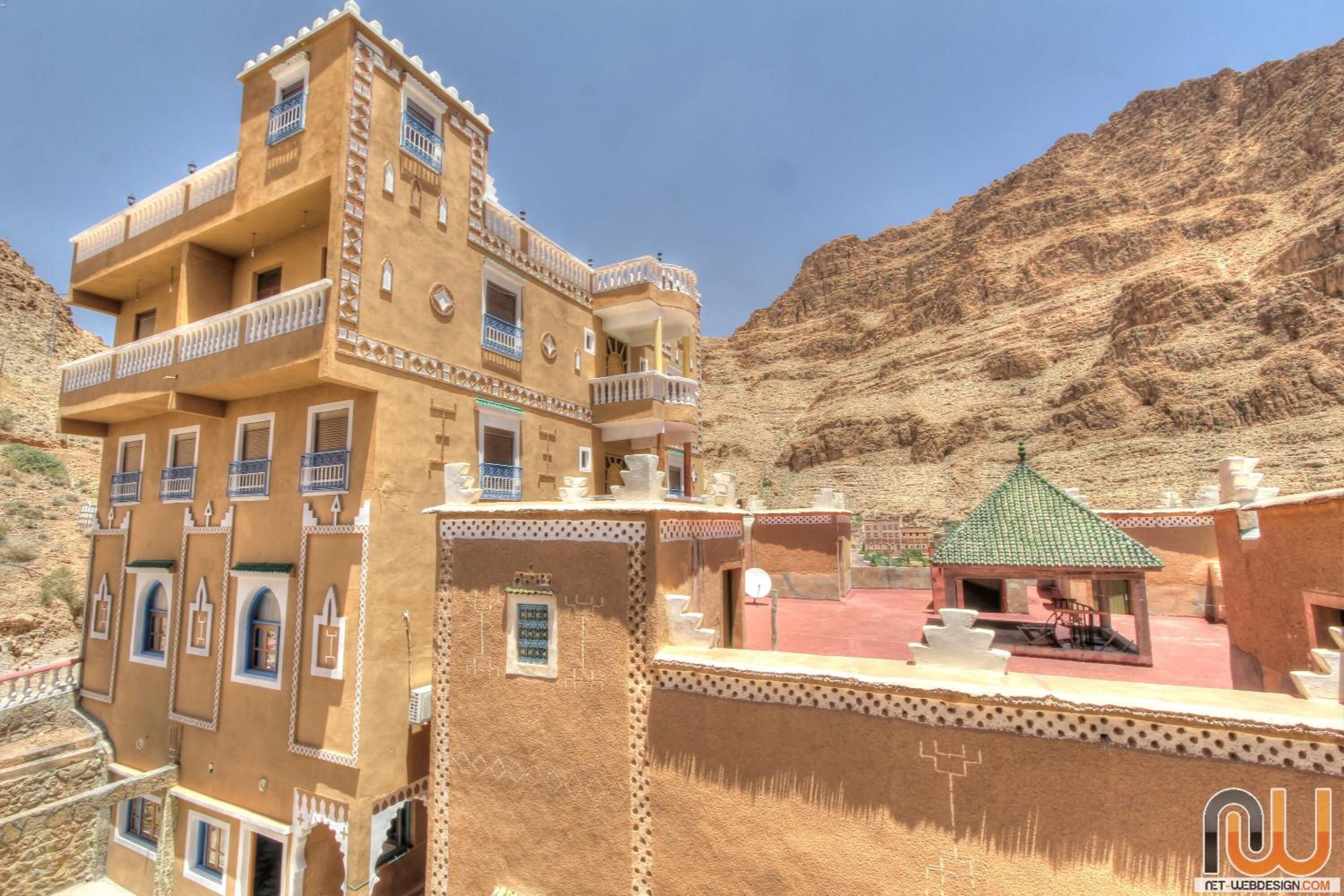 A multi-story building with balconies and a small pavilion.