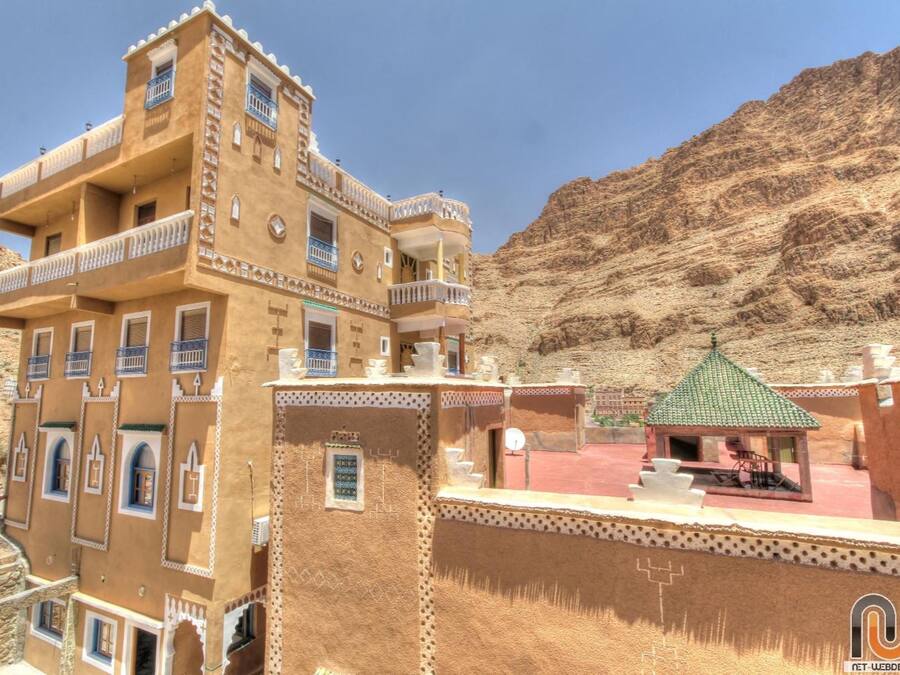 A multi-story building with balconies and a small pavilion.
