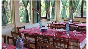 A dining area with tables set for multiple guests, featuring plaid tablecloths and wooden chairs. - Agriturismo Aurea (Crucoli)