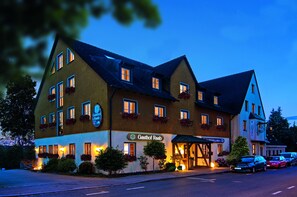 Vista frontal de la propiedad por la tarde o noche