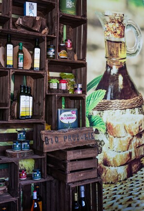 A wooden display with various food products and a large bottle of olive oil. - Bahia del Sol (Calvia)