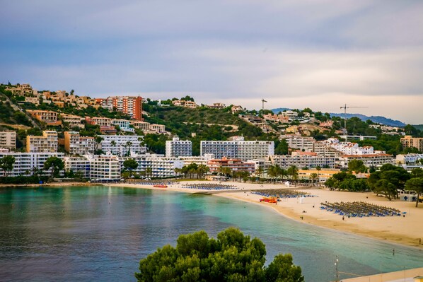 A coastal town with a beach, hotels, and a hilly backdrop. - Bahia del Sol (Calvia)