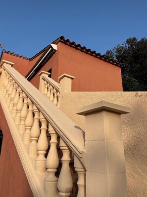 A staircase with balustrades leading to a building with a red facade and a brown roof. - CHARMING HOUSE FOR RENT - BEGUR 4 bedrooms (8/9 People) (Begur)