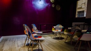 A room with wooden flooring, purple walls, and several uniquely patterned chairs. - Affittacamere Opera House (Rome)