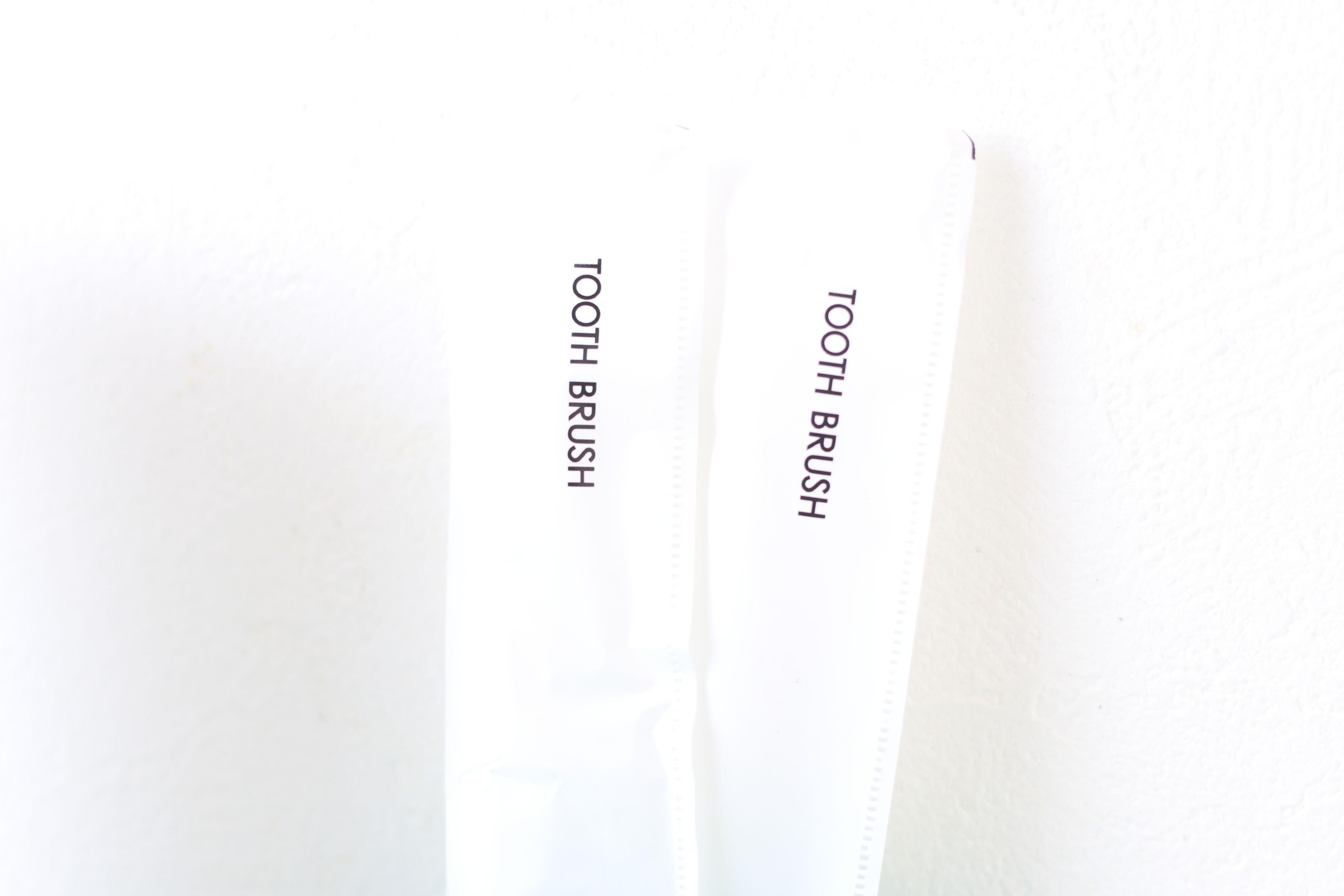 A white zipper with the text "TOOTH BRUSH" on it.