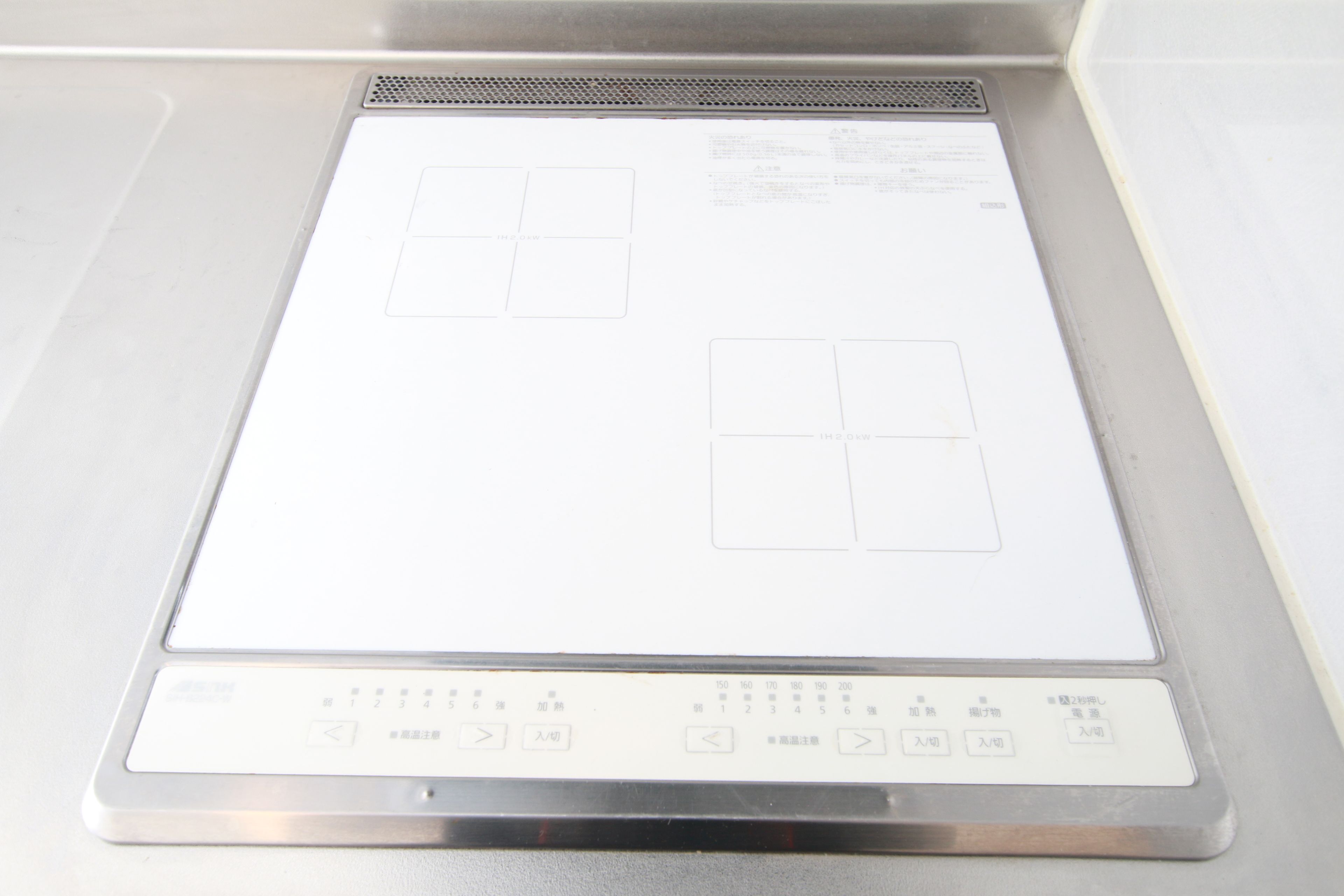 Una cocina con encimera de acero inoxidable, estufa integrada y microondas.
