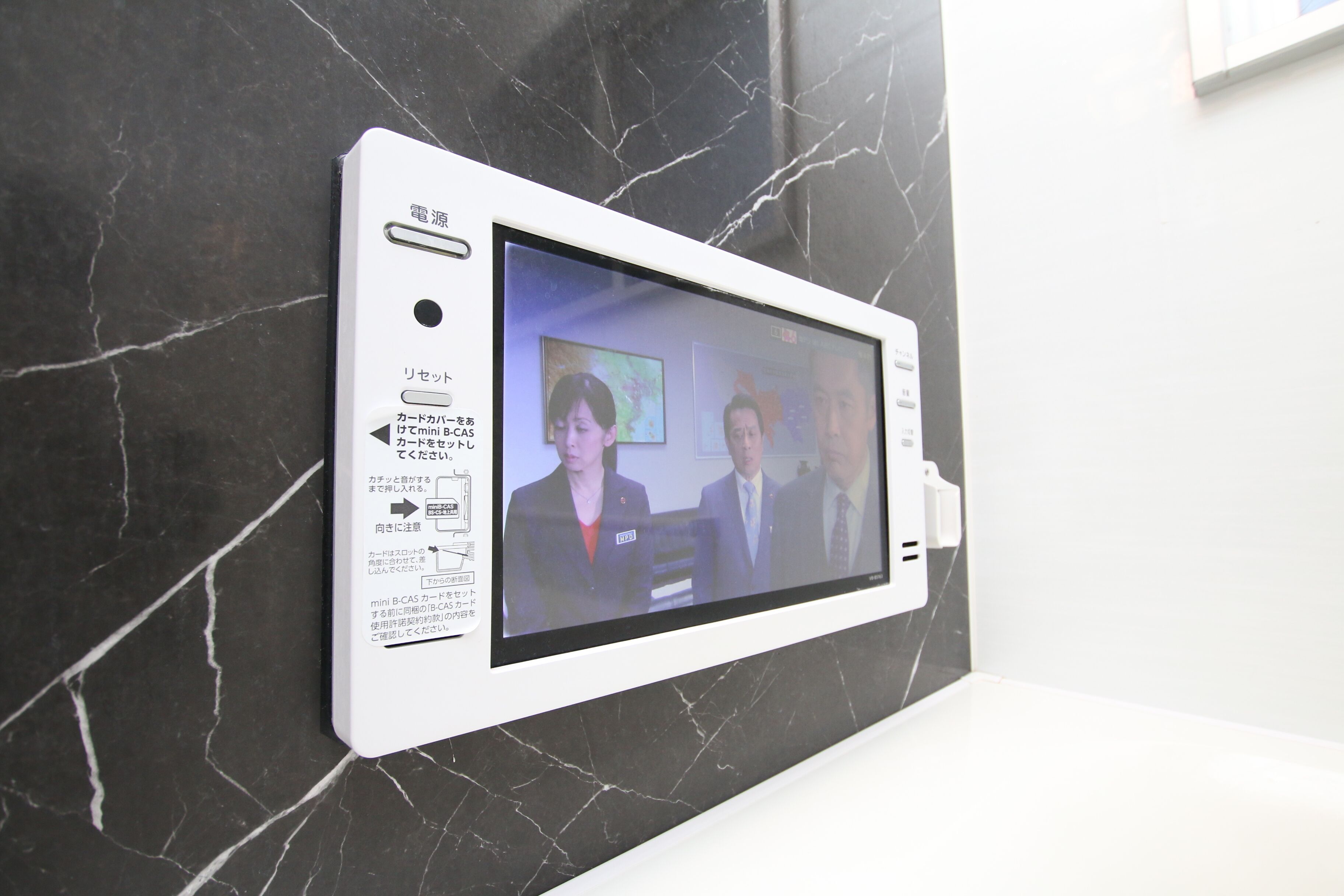 A wall-mounted device displaying a video call interface.