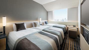 A hotel room with two beds, a desk, a chair, a TV, and a city view.
