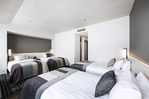 Quarto de hotel com duas camas, um espelho grande e design moderno.