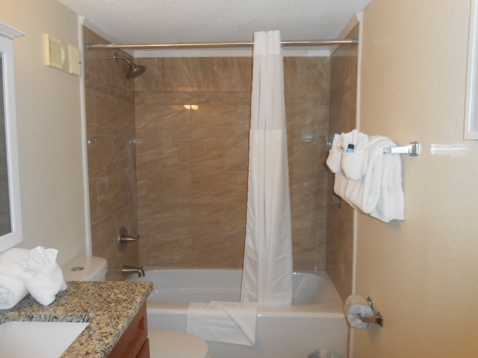 A modern bathroom with a shower, toilet, and bathtub.