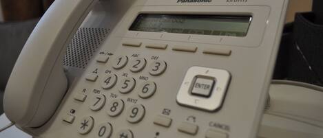 A Panasonic KX-UT113 office phone with a numeric keypad and a small display screen.