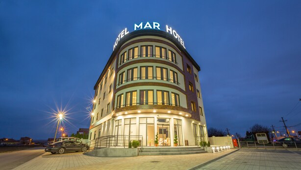 A hotel with a curved facade, multiple windows, and a sign reading "Hotel Mar Hotel". - Hotel Mar Garni (Belgrade)