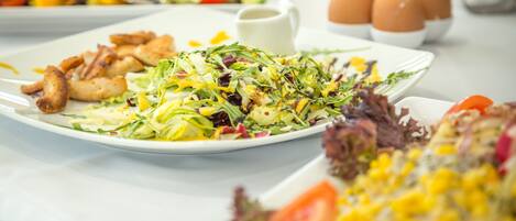 A buffet table with various dishes including salads, meats, and eggs.