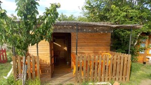 A wooden cabin with a porch and a fenced entrance. - Yourte Mongole (Huriel)