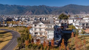A modern hotel with a two-story structure, a visible entrance, and a parking area. - Meili Xiangyue Villa Verde (Dali)