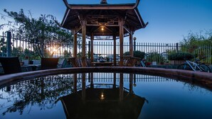 A gazebo with a reflective pool in front, surrounded by potted plants and a bicycle. - Meili Xiangyue Villa Verde (Dali)