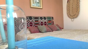 A bed with a blue bedspread, a patterned headboard, and several pillows. - Cosy Marsa Plage (La Marsa)