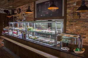A buffet counter with various food items and a menu board above. - Hotel Gorecznik (Przygodzice)