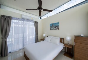 A hotel room with a large bed, two bedside tables with lamps, a ceiling fan, and a painting on the wall. - 3 BDR Laguna Park Phuket Townhome Nr 16 (Choeng Thale)