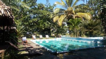 Alberca al aire libre y camastros