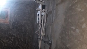 Un baño con ducha, ventana y un calentador de pared.
