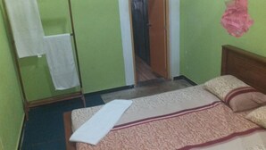 Una habitación con una cama, un espejo y una puerta que da a otra habitación.