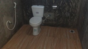 Un baño pequeño con inodoro, ducha y pared de mármol.