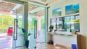 A reception area with a glass door, a reception desk, a plant, and a window with a 'RECEPTION' sign.