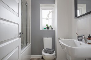 A bathroom with a shower, toilet, and bathtub.
