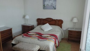 A bedroom with a wooden bed, two bedside tables, a nightstand, a bench, and a painting on the wall. - Floor 180 meters downtown area (Valencia)