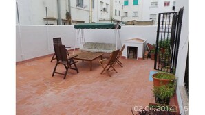 A patio with a table and chairs, a small sofa, and a green canopy. - Floor 180 meters downtown area (Valencia)