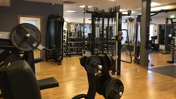 A gym with various exercise equipment, including weight machines and free weights. - Hotell Gustaf (Götene)