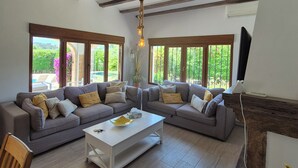 Una sala moderna con un sofá modular, una mesa de centro y un techo de madera con vigas a la vista.