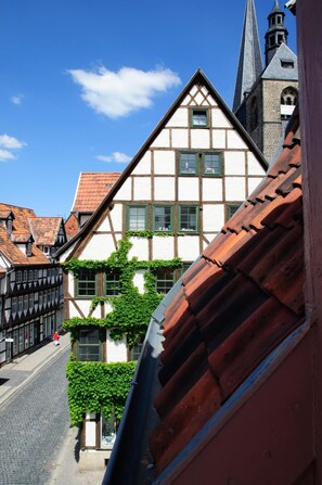 A traditional half-timbered building with a steeply pitched roof and a visible church spire in the background. - Hotel am Hoken (Quedlinburg)
