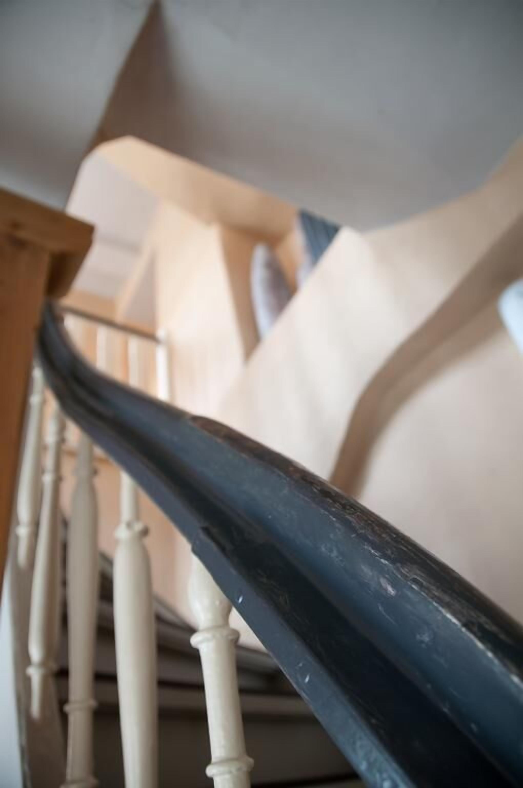 A staircase with a wooden handrail and white balusters.