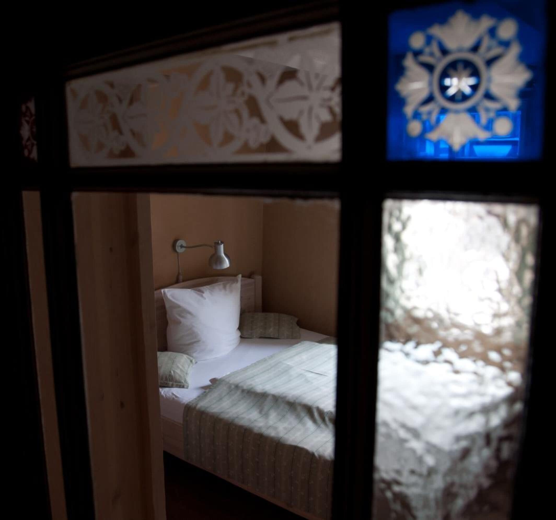 Ein Schlafzimmer mit einem Bett, Kissen und einer Wandlampe.