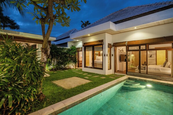 Enjoy a serene retreat with a garden and pool, surrounded by lush greenery and large windows.
