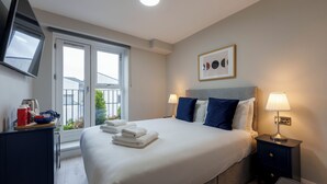 A hotel room with a bed, bedside tables, a flat-screen TV, a window with a view, and a framed picture on the wall. - The Temple Bar Lane (Dublin)