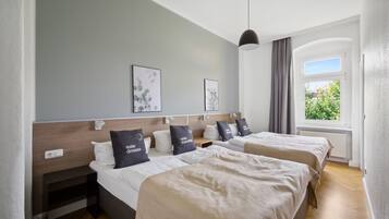 Ett hotellrum med två sängar, ett stort fönster med utsikt och en modern design.