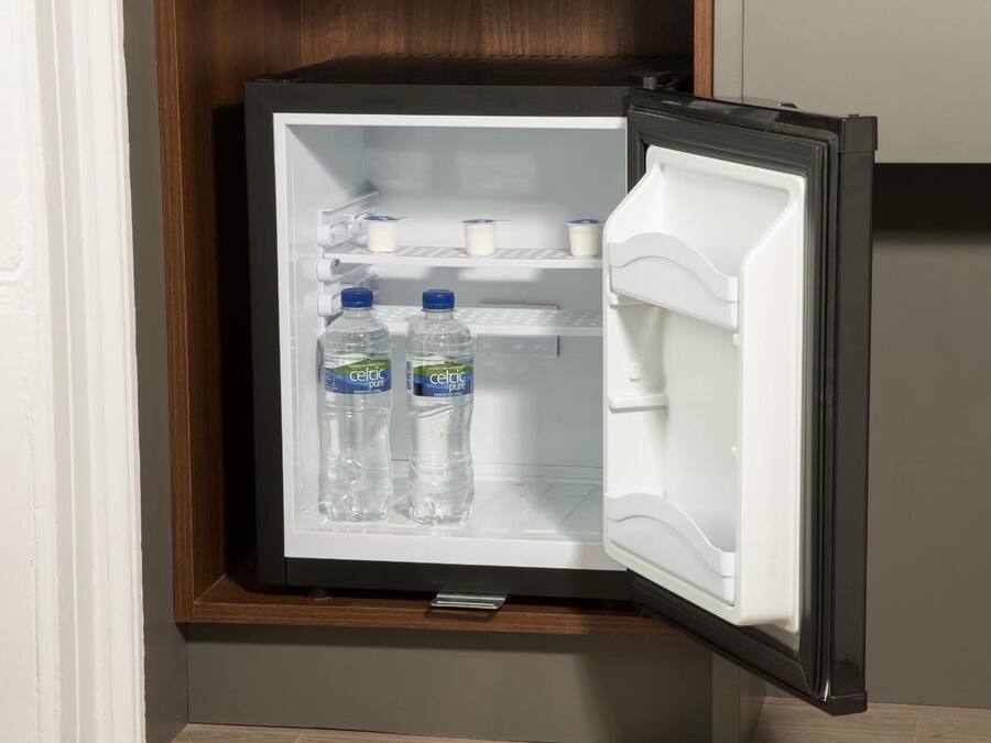 Un refrigerador compacte amb dues amples de Celiac Pure, una llet i un petit recipient a l'estant de la porta.