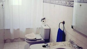 Une salle de bain équipée de toilettes, d’un bidet et d’un lavabo.