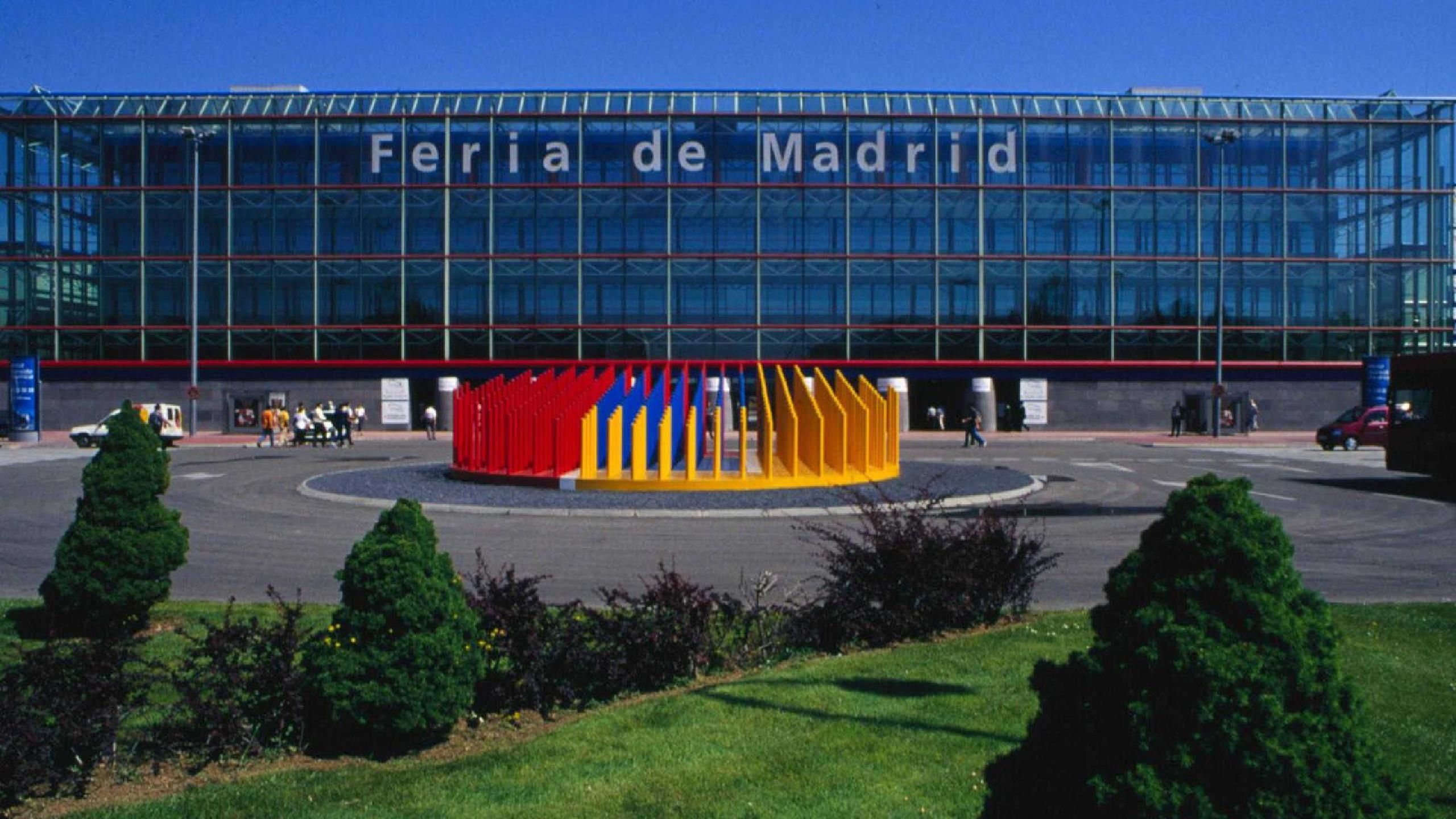 A modern stadium with a glass facade and the text "Feria de Madrid" on it.