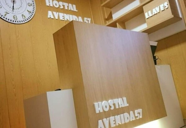 Un mostrador de recepción de madera con el texto 