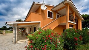 Ein zweistöckiges Haus mit Balkon und Satellitenschüssel.
