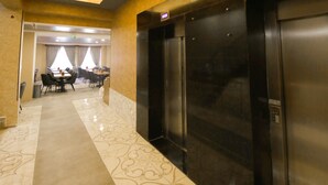 A hotel lobby with a marble floor, a reception desk, and a conference room in the background. - Taht Palace Hotel (Van)