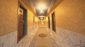 A hotel hallway with a polished floor, a chandelier, and a sign indicating room number 517. - Taht Palace Hotel (Van)